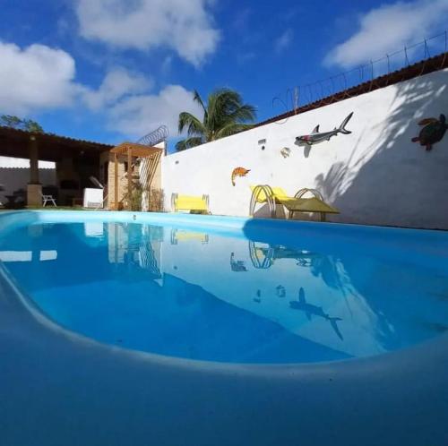 uma piscina com água azul em frente a um edifício em Aloha Kite House em Lagoinha