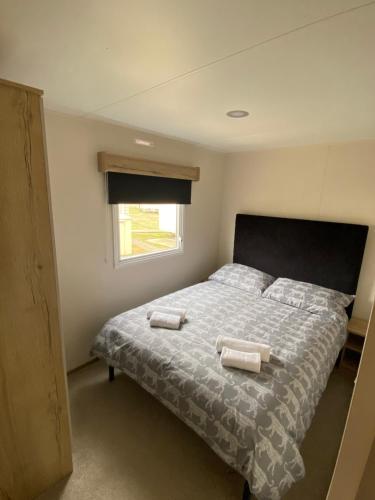 a bedroom with a bed with two towels on it at Modern & Homley 3BR Caravan in Hastings