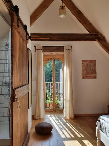 a bedroom with a large window and a bed in a room at La Kahana - cottage paisible, jardin fleuri & permaculture in Lescouët-Gouarec