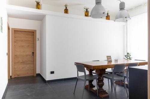 a dining room with a wooden table and chairs at AMARENA B&B Porto Recanati in Porto Recanati