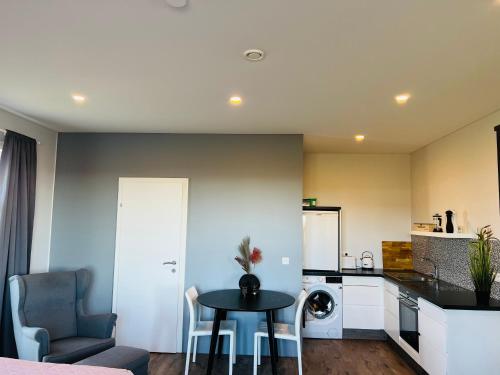a living room with a table and a kitchen at Nyibaer studio apartment in Selfoss