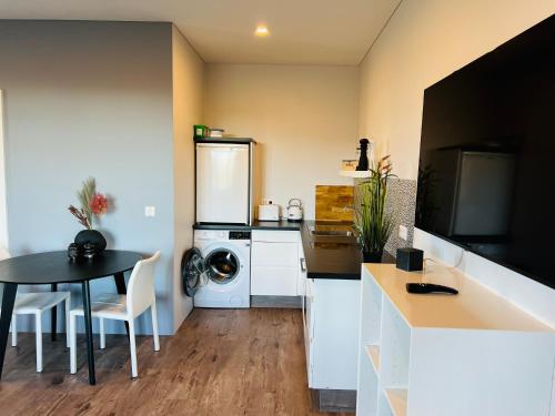 una pequeña cocina con mesa y lavadora en Nyibaer studio apartment en Selfoss
