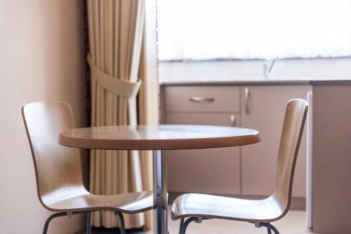 a small table and two chairs in a kitchen at Bomaderry Motor Inn in Nowra