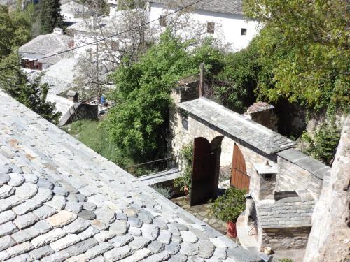 a woman standing on the steps of a stone building at Archontiko Koilia in Makrinítsa