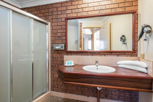 a bathroom with a sink and a mirror at Bomaderry Motor Inn in Nowra