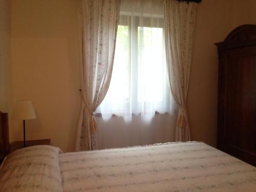 a bedroom with a bed and a window at Casa Aldo Lago di Ledro in Ledro