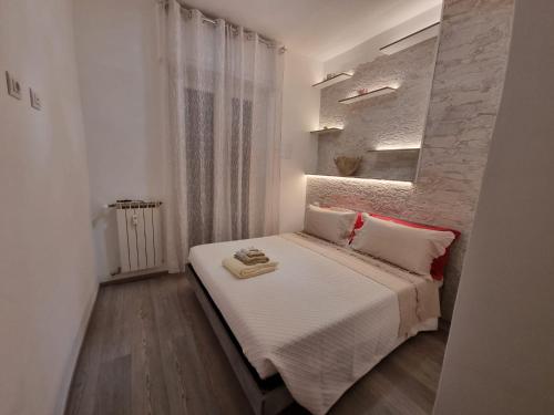 a bedroom with a bed with white sheets and red pillows at Casa Vacanza 5 Terre in La Spezia