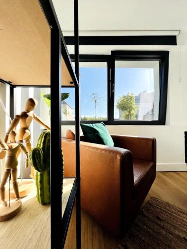 a living room with a couch and a doll next to a window at Sfeervolle vakantiewoning aan zee in Ostend