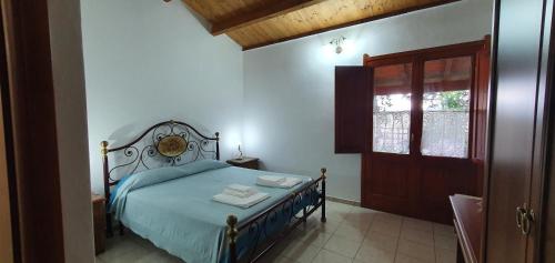 a bedroom with a bed and a door with towels on it at Bungalow Coronas in Bonorva