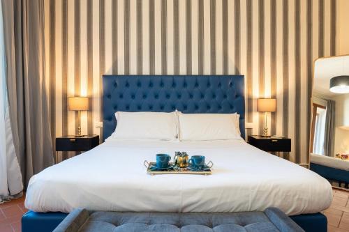 a bedroom with a large bed with a blue headboard at SPIRIT OF FLORENCE Boutique Rooms in Florence