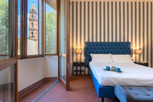Un dormitorio con una cama azul y una ventana en SPIRIT OF FLORENCE Boutique Rooms en Florence