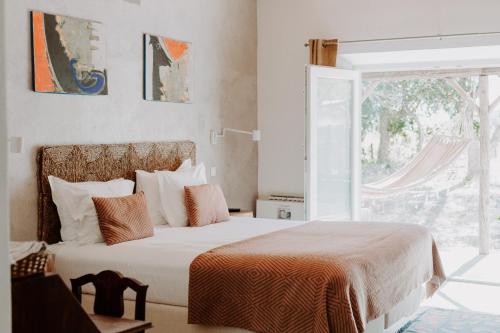 a bedroom with a large bed and a window at Ponte Pedra Melides -Nature & Ocean- Adults Only in Melides