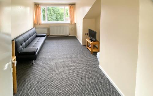 a living room with a couch and a television at Headrose House in West Bromwich