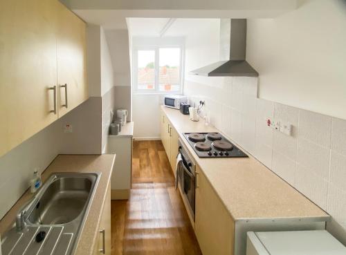 uma cozinha com um lavatório e um fogão forno superior em Headrose House em West Bromwich