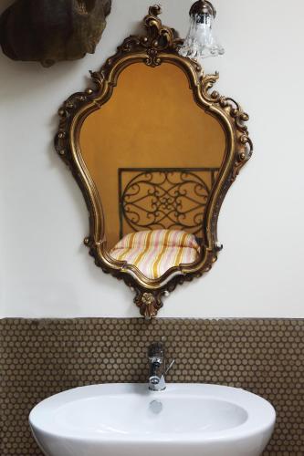 a mirror on a wall above a sink at DormidaNoi B&B in Civitanova Marche