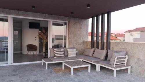 a patio with a couch and a table on a balcony at Villa Queen in Zadar