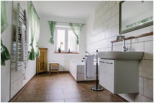 a bathroom with a sink and a bath tub at Gästehaus Niedermeierhof in Ebersberg