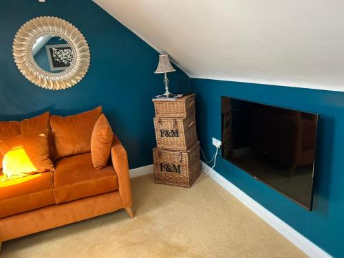 a living room with a couch and a television at Boutique Shrewsbury Suites in Shrewsbury