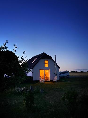 a small house with a car in front of it at Hyggehytten auf Bornholm in Østermarie