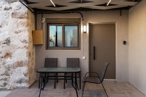 een tafel en stoelen in een kamer met een raam bij Thea Studio in Agios Padeleimon