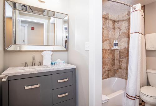 a bathroom with a sink and a toilet and a mirror at Fresh and Modern Superior Deluxe Top Floor Hotel Room Walk to Skiing Restaurants Shops in Park City