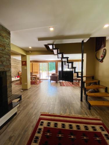 a living room with a staircase and a fireplace at Brezovica Luxury Villa in Brezovica