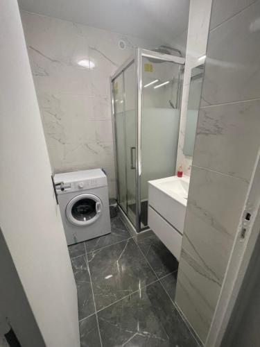 La salle de bains est pourvue d'une douche et d'un lave-linge. dans l'établissement Appartement Lagny sur Marne DisneyLand Paris, à Lagny-sur-Marne