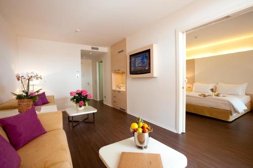 a hotel room with a bed and a living room at Laguna Palace Hotel Grado in Grado