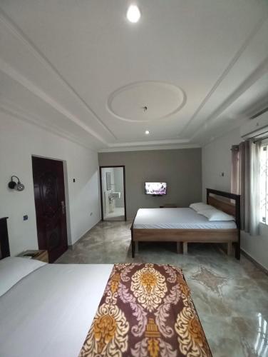 ein großes Schlafzimmer mit 2 Betten und einem Fenster in der Unterkunft BAFFOUR STUDIO in Kumasi