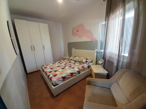 a small bedroom with a bed and a chair at SOGNO Vacanze in Massa