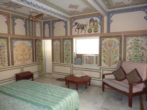 a bedroom with a bed and a couch and a window at Tourist Pension in Nawalgarh