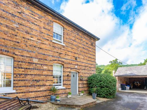 a brick house with a bench in front of it at Riverside in Craven Arms