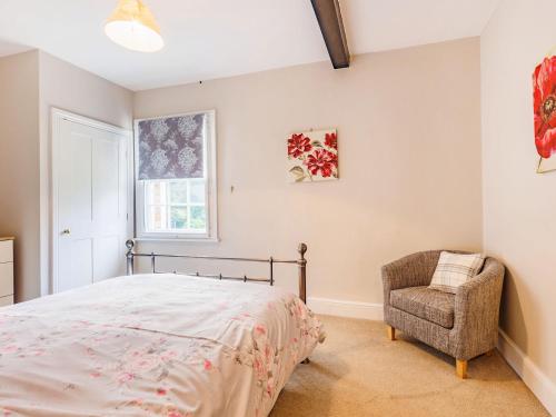 a bedroom with a bed and a chair at Riverside in Craven Arms
