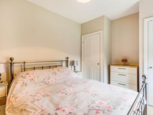 a bedroom with a bed with pink flowers on it at Riverside in Craven Arms