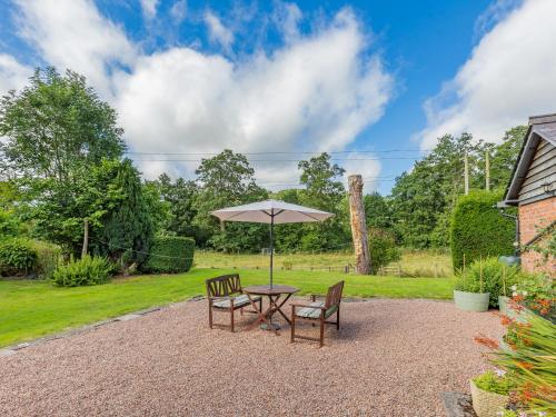 a table with two chairs and an umbrella at Riverside in Craven Arms
