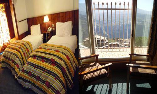 a hotel room with two beds and a large window at Hotel Chbat in Bcharré