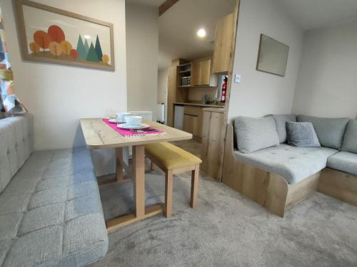 a small living room with a table and a couch at 3 Bedroom Luxury Caravan - Vans With Business Sign Not Allowed in Port Seton
