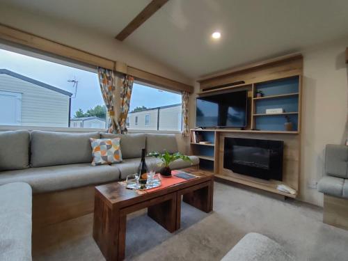 a living room with a couch and a fireplace at 3 Bedroom Luxury Caravan - Vans With Business Sign Not Allowed in Port Seton