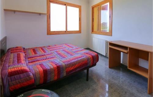 1 dormitorio con 1 cama, escritorio y ventanas en 4 Bedroom Gorgeous Home In Sant Cebria De Vallalt, en Sant Cebrià de Vallalta