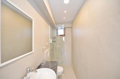 a bathroom with a sink and a toilet and a mirror at Apartments Langust in Sveti Stefan
