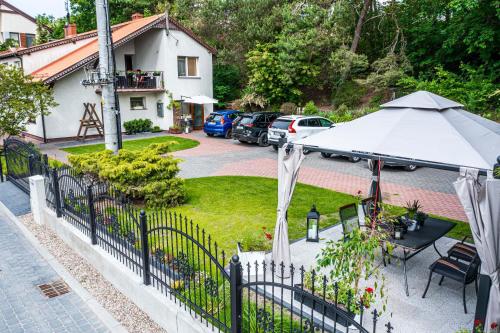 ogród z białym parasolem i domem w obiekcie Pokoje Gościnne Sylwia w mieście Krynica Morska