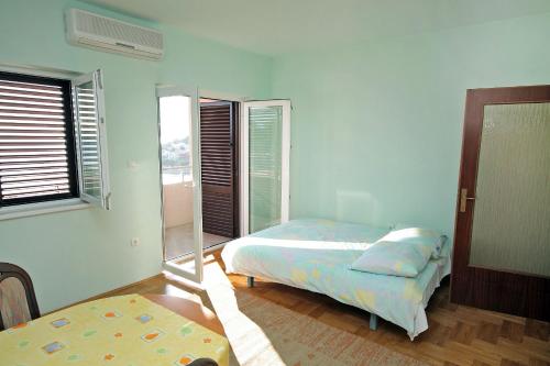 a bedroom with two beds and a window at Apartments by the sea Bilo, Primosten - 4806 in Podgreben
