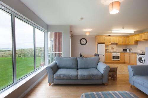 a living room with a couch and a large window at Portrush Seaview Apartments in Portrush