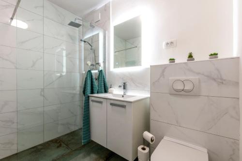 a white bathroom with a sink and a toilet at New Luxury Bella Apartment in Split