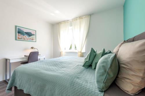 Un dormitorio con una cama grande con almohadas verdes. en New Luxury Bella Apartment, en Split