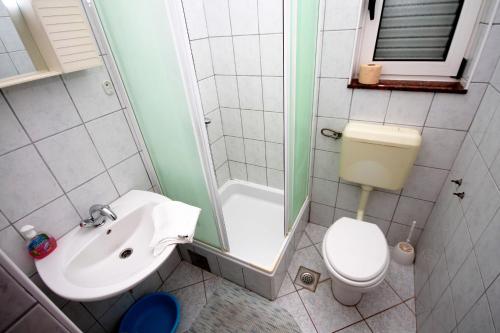 a bathroom with a sink and a toilet and a shower at Apartments with a parking space Grebastica, Sibenik - 4867 in Grebaštica