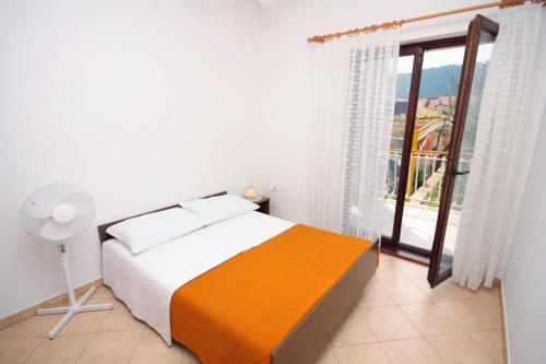 a white bedroom with a bed and a window at Apartments with a parking space Grebastica, Sibenik - 4867 in Grebaštica