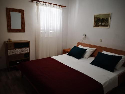 sypialnia z dużym łóżkiem z 2 niebieskimi poduszkami w obiekcie Apartments with a parking space Jezera, Murter - 5135 w mieście Jezera