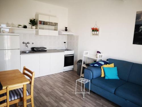 uma sala de estar com um sofá azul e uma cozinha em Apartments with a parking space Jezera, Murter - 5135 em Jezera