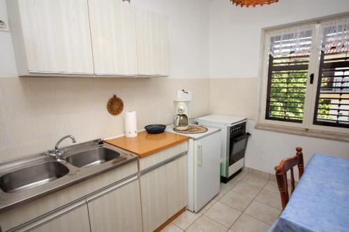a small kitchen with a sink and a stove at Apartments by the sea Jezera, Murter - 5074 in Jezera